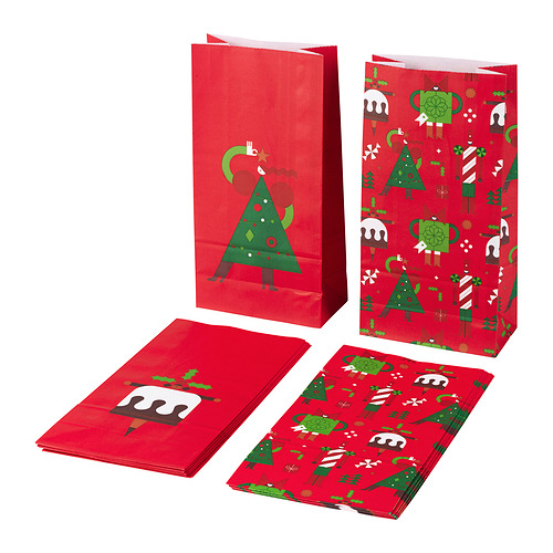 Cuatro bolsas de papel rojas, tres verticales con diseños de árboles de Navidad verdes, un piso con un hombre de jengibre.