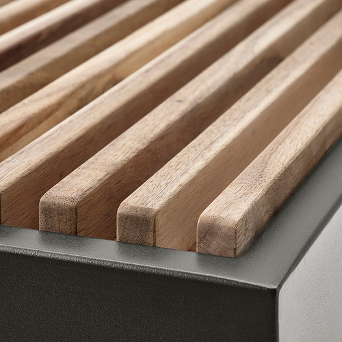 Muebles de exterior de madera, primer plano que muestra el asiento de listones y la estructura de metal, resaltando la artesanía y la durabilidad.