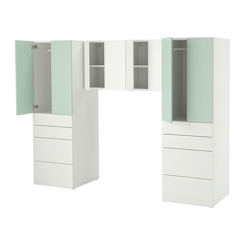 Moderno mueble de almacenaje blanco para niños con varios cajones y armarios de varios tamaños, incluido un armario. Los acentos en verde claro añaden un toque divertido.