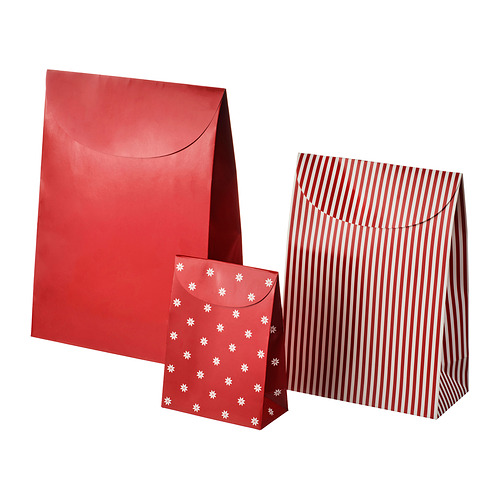 Tres bolsas de papel rojas. Uno es liso, otro tiene estrellas blancas y el tercero rayas rojas y blancas.