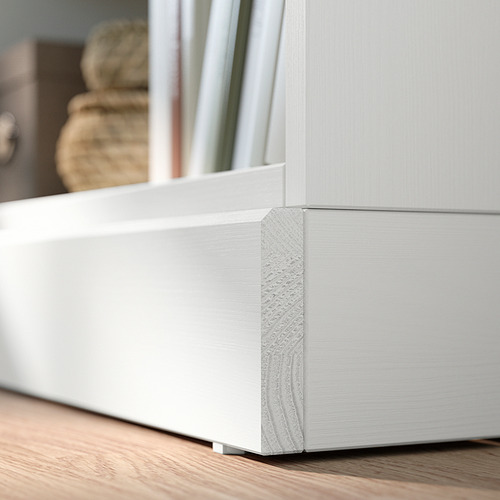 Mueble de almacenaje de pino HAVSTA blanco con detalle de esquina, base de madera.