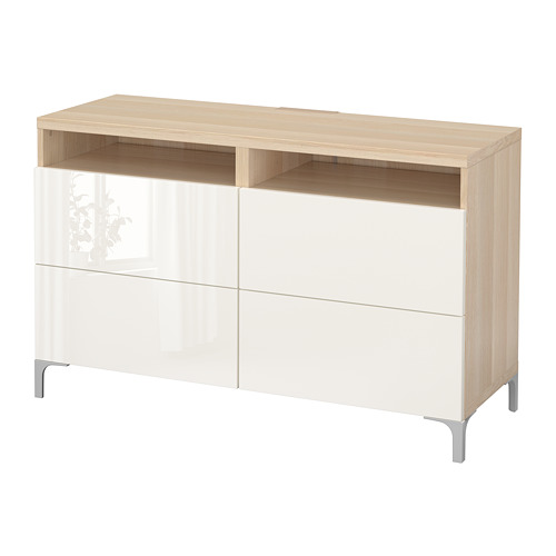 Se trata de una consola de televisión BESTÅ, blanca y de madera, con cajones y estantes abiertos. Es elegante y moderno.