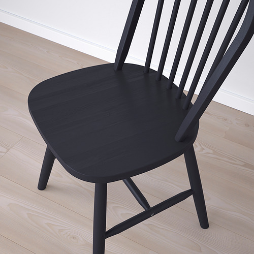 Silla moderna de color negro con diseño elegante sobre suelo de madera clara. Silla con ocho husillos en el respaldo y patas robustas, que reflejan calidad y durabilidad.
