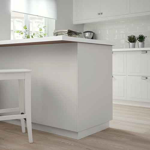 Cocina moderna blanca con panel de cubierta STENSUND en madera clara. Diseño minimalista.