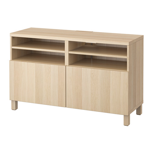 Mueble de TV de madera de color claro con dos armarios y dos estantes abiertos para almacenamiento.