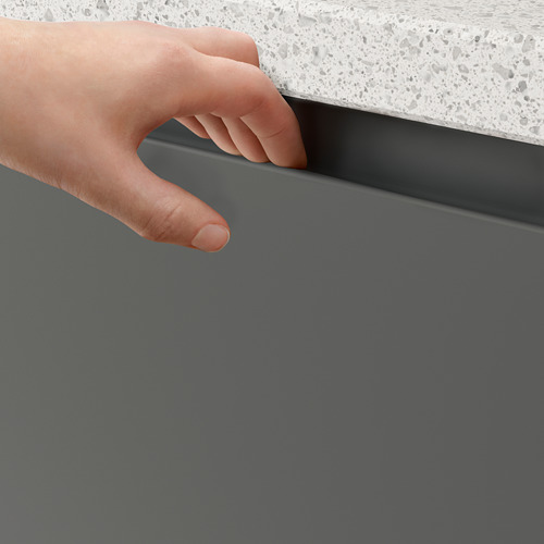 El armario VOXTORP se abre a mano, revelando un diseño de cocina moderno con tiradores integrados.