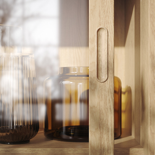 Armario de madera con puerta corredera con asa elegante, frascos de vidrio transparente en el estante.