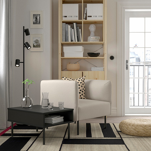 Sala de estar minimalista con sofá blanco, mesa de centro negra, estantería alta y ventana grande.