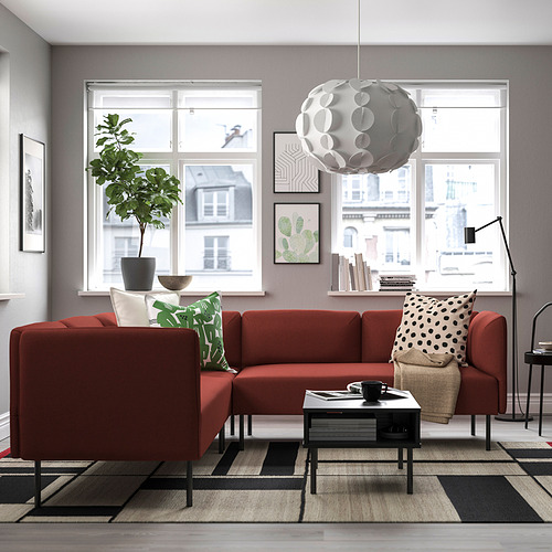 Sala de estar moderna con seccional naranja, alfombra y vista a la ciudad.