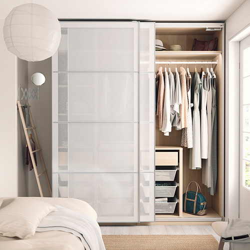 Dormitorio moderno y minimalista con armario blanco PAX con ropa y accesorios, una escalera colgante con chaquetas y un ambiente acogedor.