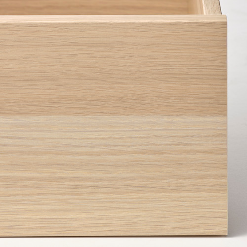 Primer plano de un elegante cajón de madera clara con superficie lisa y textura de grano fino.