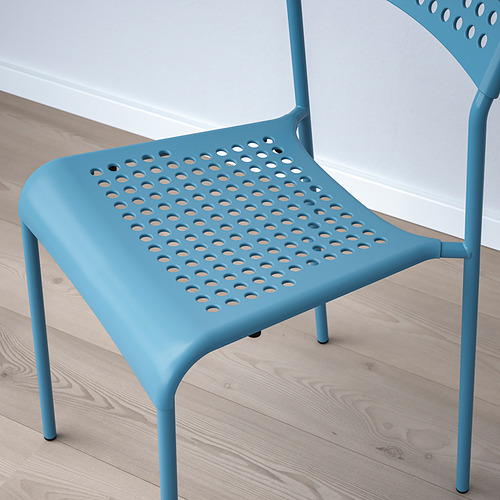 Silla de plástico azul con orificios en el asiento y el respaldo para el flujo de aire. Ligero, apilable, se asienta sobre un suelo de madera de color claro.