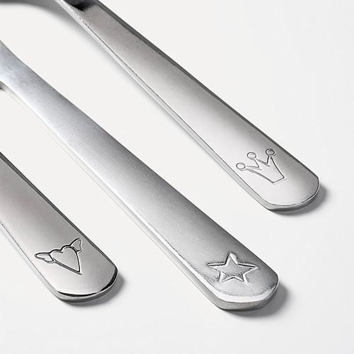 Tres utensilios infantiles de acero inoxidable: cuchillo, tenedor, cuchara, cada uno con diseños grabados únicos.