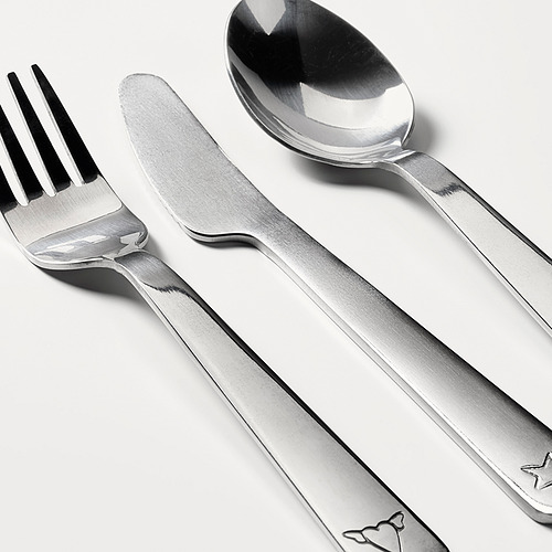 Juego de cubiertos afilados y pulidos: tenedor, cuchillo, cuchara, cuidadosamente dispuestos en blanco.