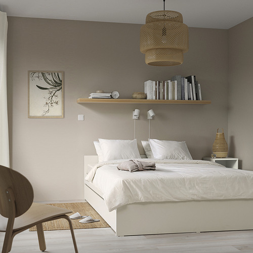 Dormitorio minimalista con estructura de cama blanca VIHALS y nido, cuidadosamente hecho con ropa de cama, decoración de madera, lámpara, silla y obras de arte.