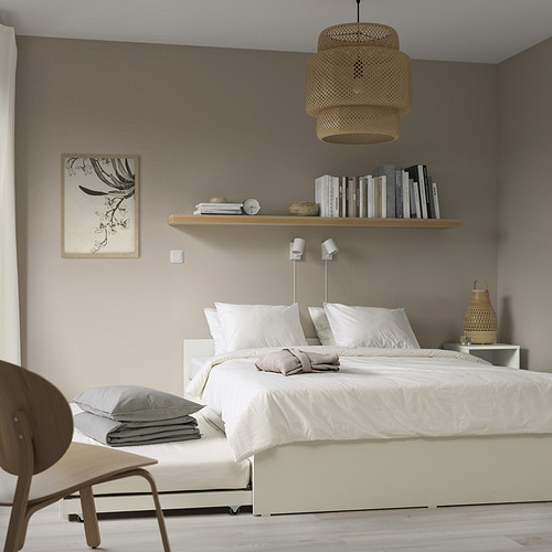 Dormitorio minimalista con cama VIHALS blanca, sábanas frescas, decoración de madera y lámpara colgante.