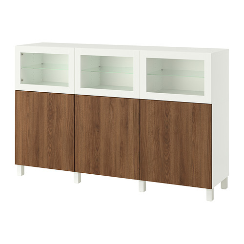 Mueble de almacenaje BESTÅ blanco con puertas de madera marrón y armarios con tapa de cristal.