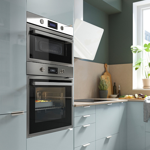 Cocina moderna con horno doble de acero inoxidable en mueble azul, microondas, controles digitales, manijas plateadas y campana blanca.