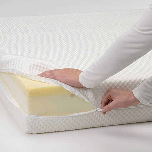 Persona con cremallera de la funda del colchón, que muestra la característica lavable del colchón de espuma firme.