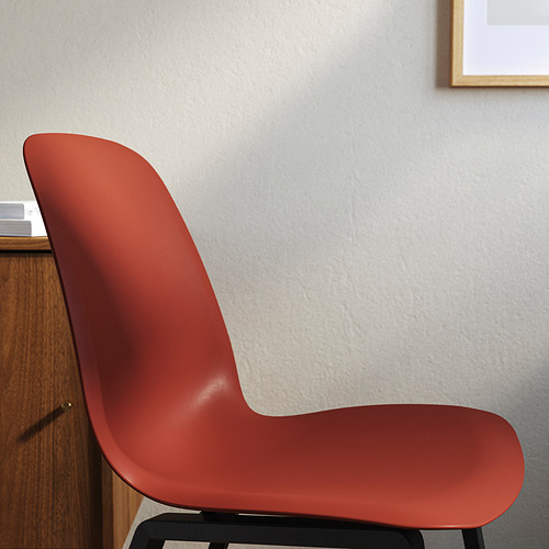 Silla moderna roja contra pared gris