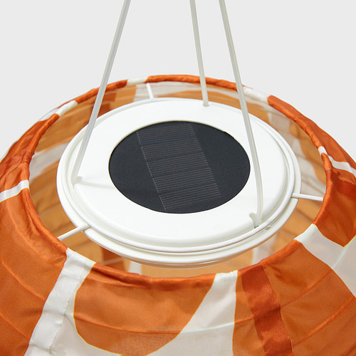 Lámpara colgante alimentada por energía solar con pantalla naranja y blanca, panel solar circular en la parte superior.