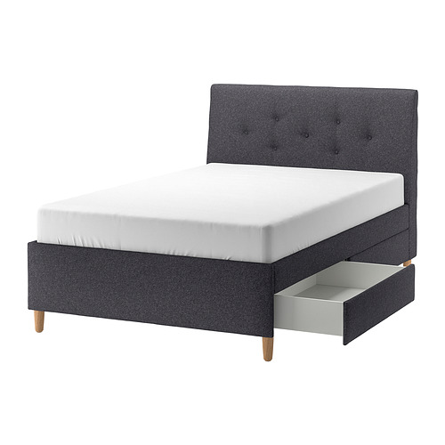 Cama tapizada en gris oscuro de IDANÄS con cabecero inclinado, patas de madera y dos cajones para almacenaje.