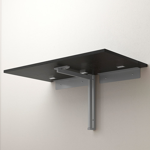 La mesa de pared negra plegable se monta en soportes metálicos, ahorrando espacio cuando no está en uso.