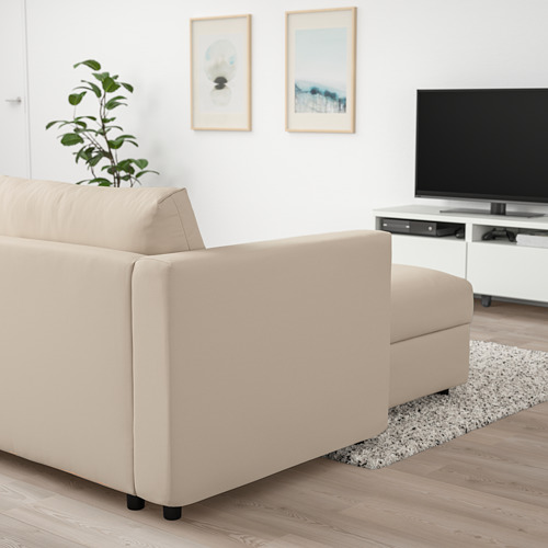 Sala de estar moderna con sofá VIMLE beige, TV grande y planta.