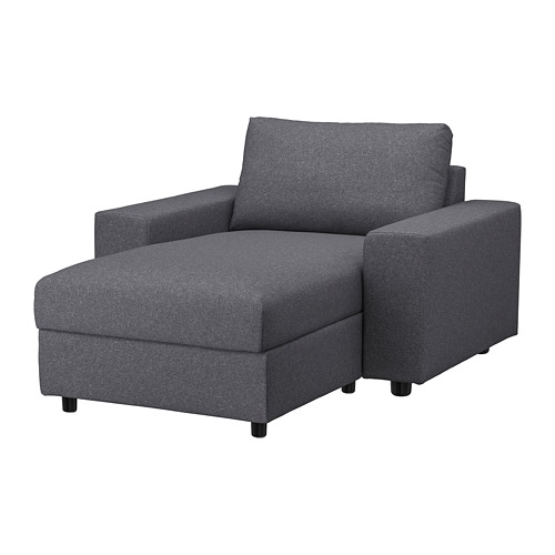 Moderno sofá de tela gris con chaise longue, brazos cuadrados y patas negras.