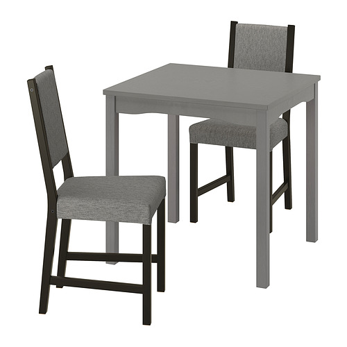 Un juego de comedor compacto y moderno con mesa gris y sillas acolchadas a juego, ideal para espacios pequeños.