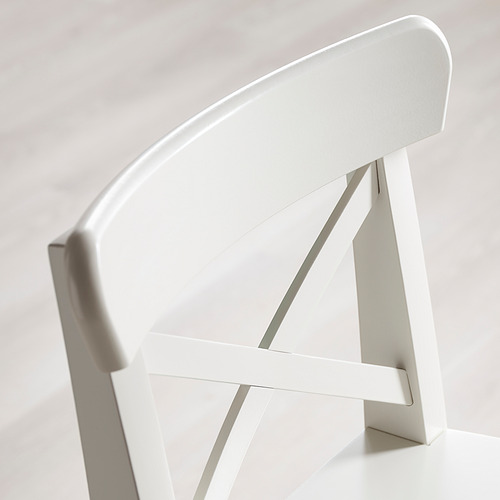 Esquina de una moderna silla blanca; diseño elegante y resistente; líneas limpias.