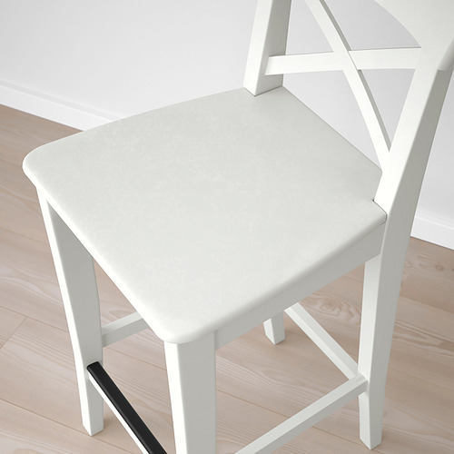 Vista superior de la silla INGOLF blanca, asiento robusto y liso con detalle de reposapiés negro.