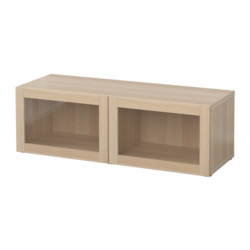 Un mueble de almacenamiento BESTÅ de madera clara con dos compartimentos abiertos sobre un fondo blanco liso.