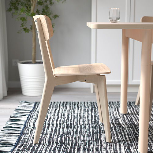 Silla de madera clara cerca de la mesa de comedor. Robusto, versátil para comer y realizar actividades.