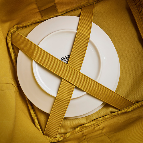 Placa blanca en bolsa de malla verde. Correas entrecruzadas, placa de sujeción. La bolsa parece duradera, bien construida.