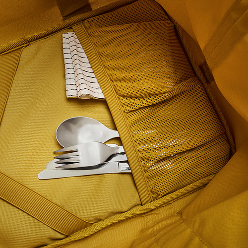 Bolsa nevera amarilla abierta con bolsillo de malla. Contiene utensilios de plata y tela blanca. Diseño aislado de alta calidad para uso en exteriores.
