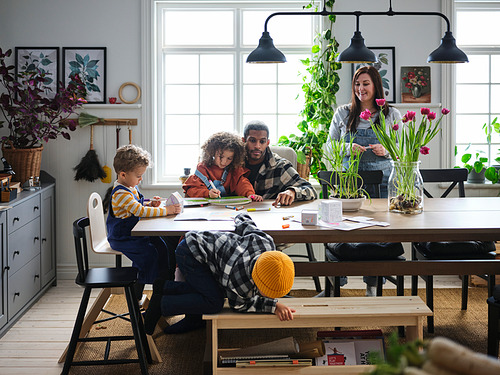 La familia se reúne alrededor de la mesa de comedor KLIMPFJÄLL; rectangular, chapa de haya, acogedor, cálido, diseño tradicional, resistente, ideal para la unión.