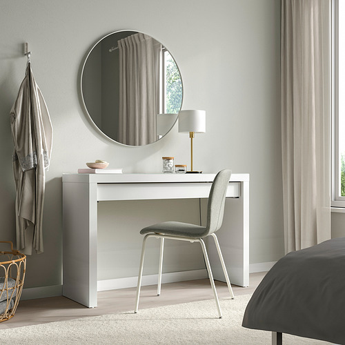 Dormitorio moderno con tocador, espejo, silla y lámpara MALM. Ventana con cortinas, colcha gris.
