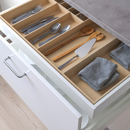 Cajón de cocina organizado con separadores de madera para cubiertos y utensilios.