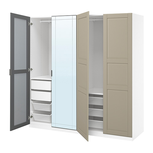 Un armario blanco abierto de ikea PAX con puerta con espejo, cestas de malla y estantes.