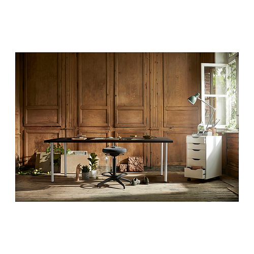 Pequeña configuración de oficina en casa con una mesa ajustable negra, una silla negra, un gabinete de almacenamiento blanco y plantas en macetas. Paredes de madera, ventana con luz natural.