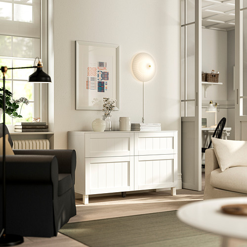 Salón moderno con aparador BESTÅ , silla, sofá y decoración.