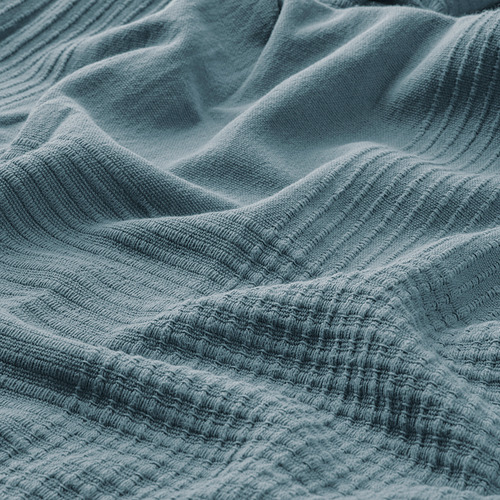 Colcha de algodón suave tejida en color verde azulado, con una textura intrincada y una artesanía de alta calidad.
