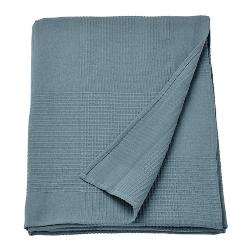 Una colcha de algodón azul INDIRA, doblada cuidadosamente, con un tejido texturizado, que ofrece calidez y comodidad.