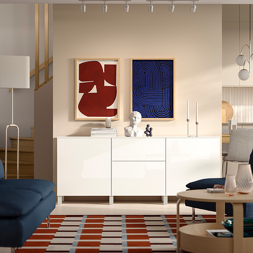 Salón moderno, aparador blanco de BESTÅ , arte colorido, silla azul, mesa de madera, iluminación de raíl.