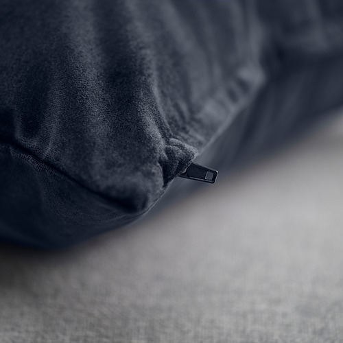 Cojín de terciopelo azul oscuro con brillo sutil, con detalle de cremallera oculta, enfatizando textura suave.