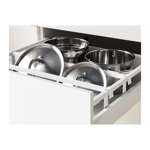 Macetas de metal en un cajón abierto de la cocina, que muestran el almacenamiento y la organización.