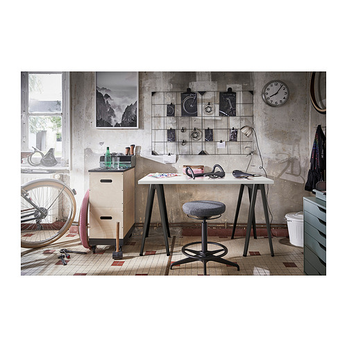 Espacio de trabajo industrial con escritorio, taburete, herramientas y decoración LAGKAPTEN.