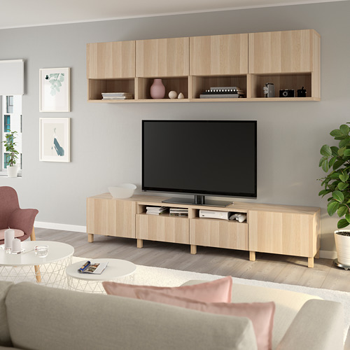 Sala de estar moderna con TV de pantalla plana, centro de entretenimiento de madera, paredes grises, arte, asientos acogedores y plantas.