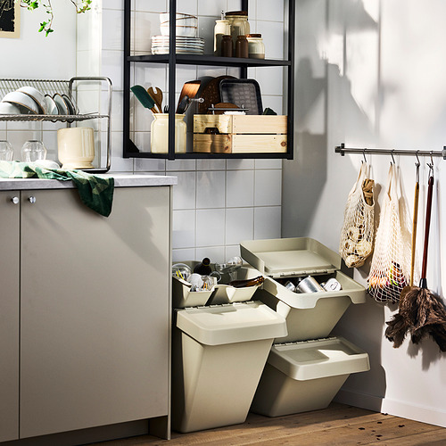 Cocina gris con papeleras y estanterías de reciclaje.